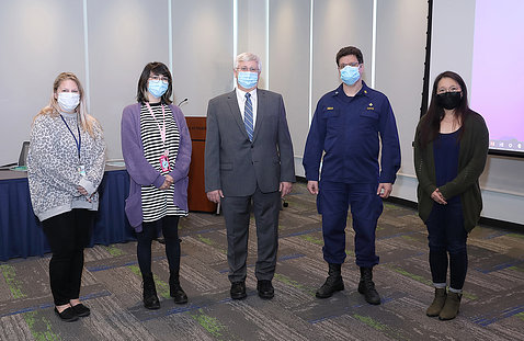 Five animal care workers, in face masks, stand for photo.