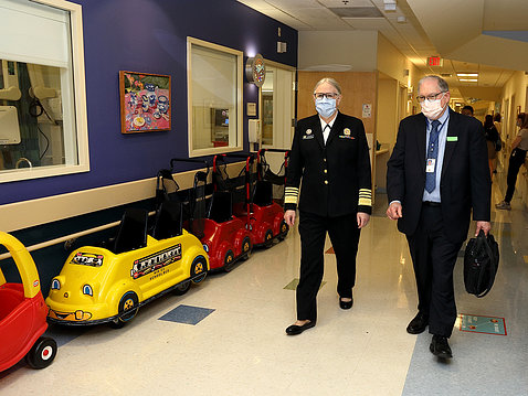 Levine and Tabak stroll through a toy-car-lined hallway