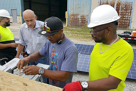 Two trainees install solar panels