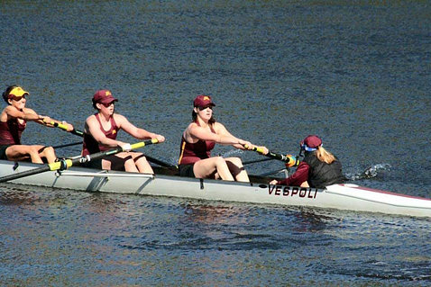 Hauser, seen from behind, leading two rowers in a boat on the lake