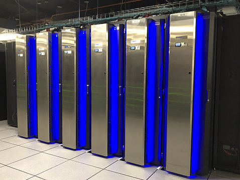 Six tall steel cabinets with bright royal blue in between - supercomputer coolers