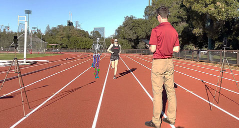 A researcher uses a camera to record someone running on a track