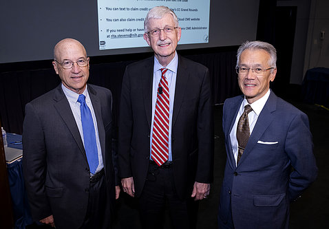 Gilman, Collins and Burklow stand together, smiling, in front of screen in Lipsett Amphitheater