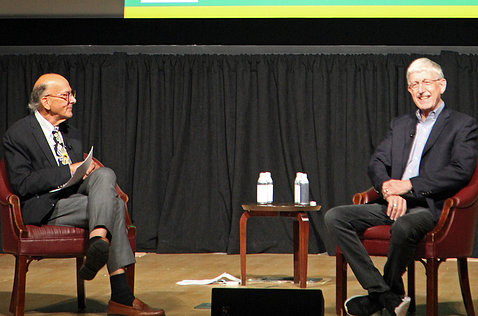 Glass, left, and Collins, right, sit opposite each other on stage