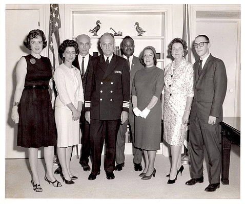 Four men--one in military uniform--and four women gather for group picture