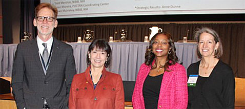 Group of four including NIH director and NIBIB director, standing, smiling