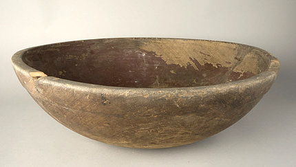 An old, chipped, wooden mixing bowl