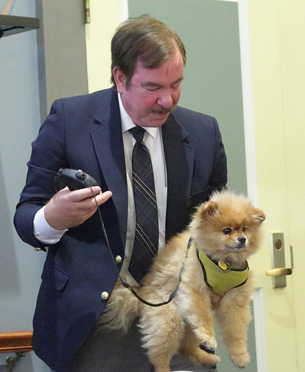 Phil Cummings holds his service dog.