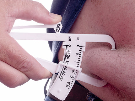 Doctor uses a skin fold caliper to measure body fat.