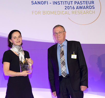 Belkaid holds her award while she stands next to Dr. Staffan Normark
