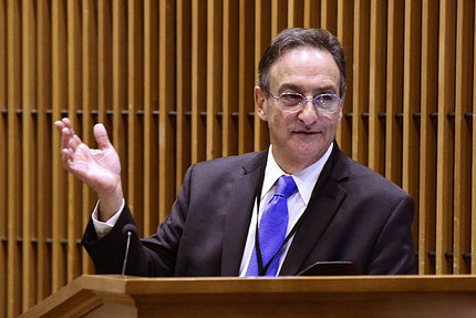 Flatow speaks in front of a podium
