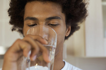 Man drinking a glass of water.