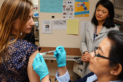A volunteer receives a vaccine in the arm