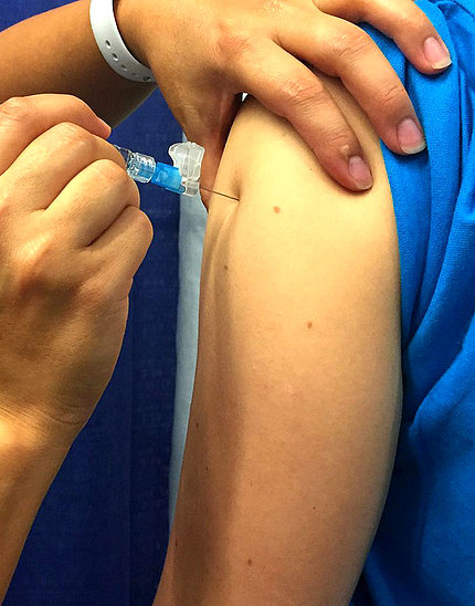 Exposed arm receiving injection