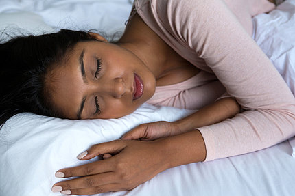A woman sleeps on her side