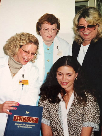 Bianchi holds up copy of Fetology textbook, surrounded by April Murphy, her mother and Dr. Ampola