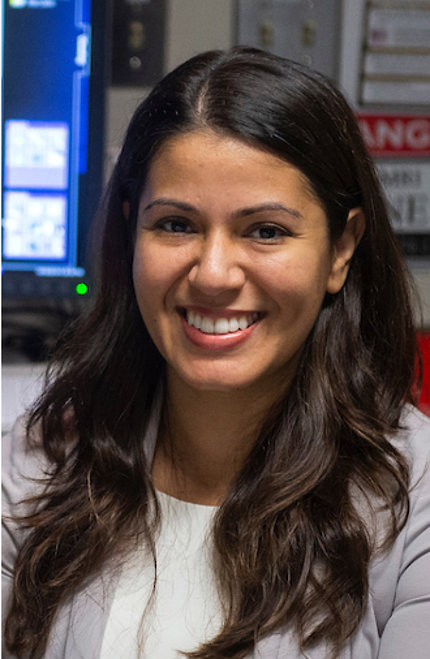A smiling Dr. Eleni Frangos in the lab