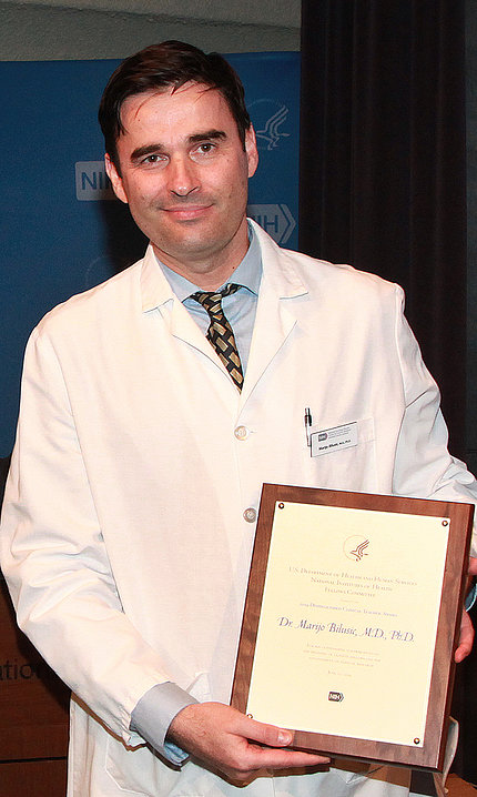 Bilusic holds plaque at 2019's award presentation.