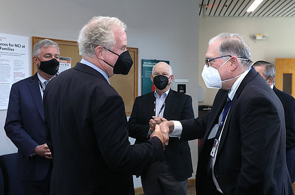 Van Hollen shakes hands with Tabak, as Trone and Cardin look on. All are wearing masks.