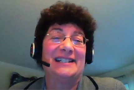 A smiling Dr. Minasian talks on videocast into her headset