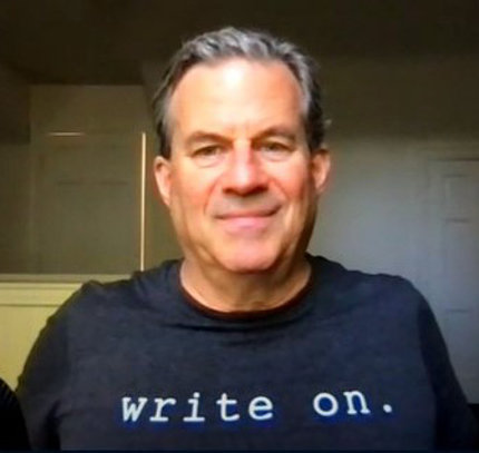 Quinones seated in black t-shirt that reads "Write On" during the event videcoast