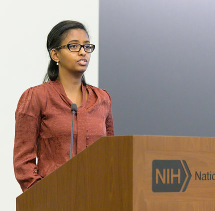Hunegnaw speaks at a podium