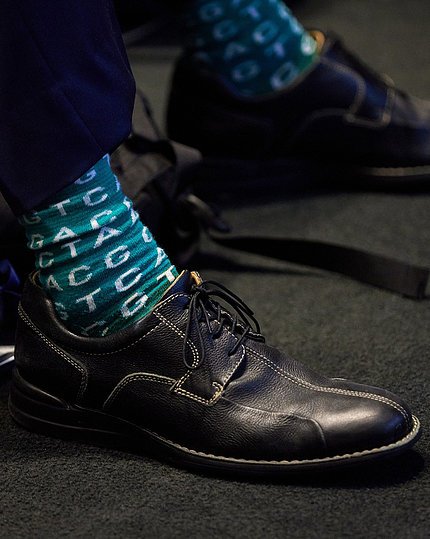 A teal sock with ACGT repeated in a pattern on the foot of a panelist