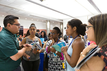 A group of students converse in a crowded room