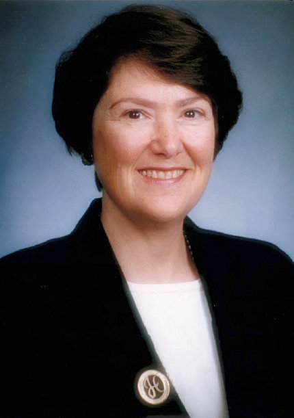  Dr. Helen Sunshine in black blazer with gold H pin