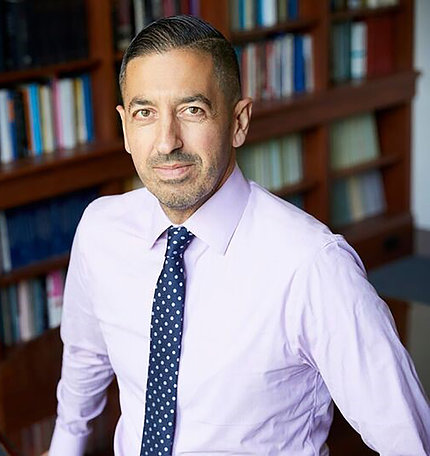 Dr. Sandro Galea standing in his office