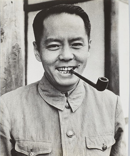 A black-and-white photo of a smiling Lim, with a pipe held in between his teeth.
