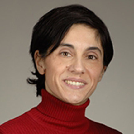 Dr. Moutsopoulos wears a red turtleneck against a plain background