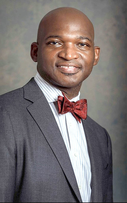headshot of black man, bald, clean-shaven, wearing suit and bowtie