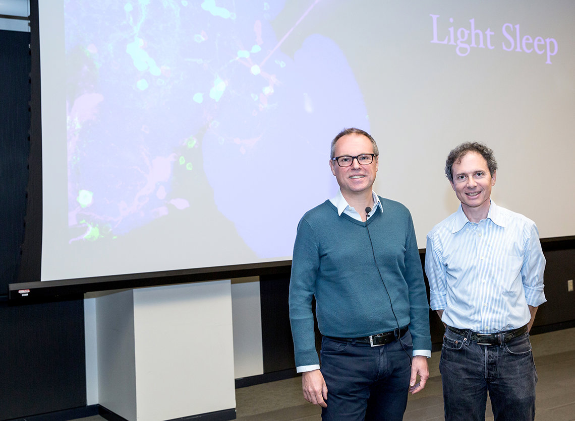 Miesenböck and Dr. Mark Stopfer stand in front of projected slide.