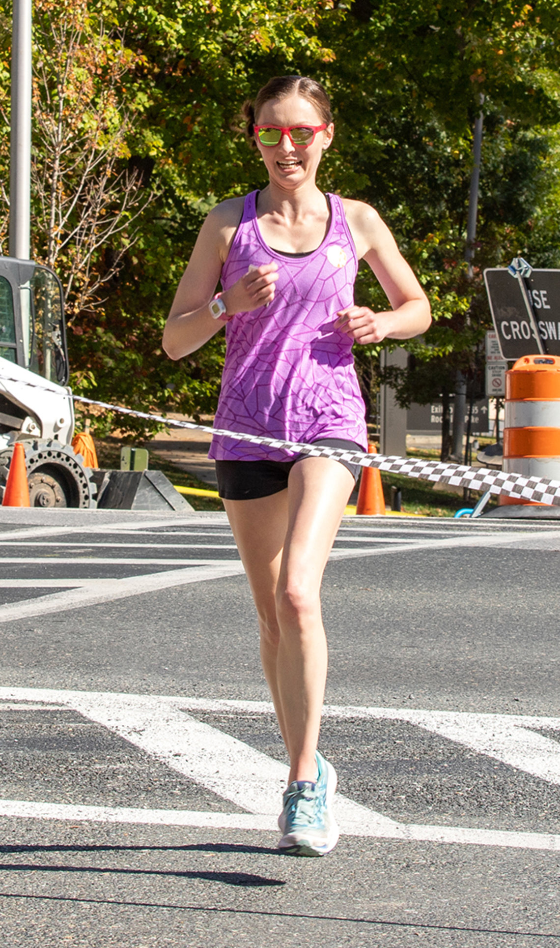 Female runner crosses finish line.