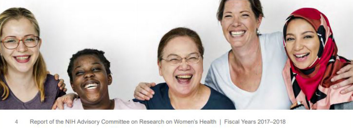 Five women of different nationalities pose together, laughing.