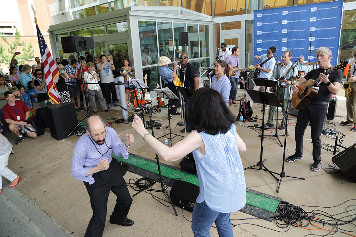 Collins rocks out on guitar performing with members of his ARRA band as NIH'ers dance on the Clinical Center south lawn.