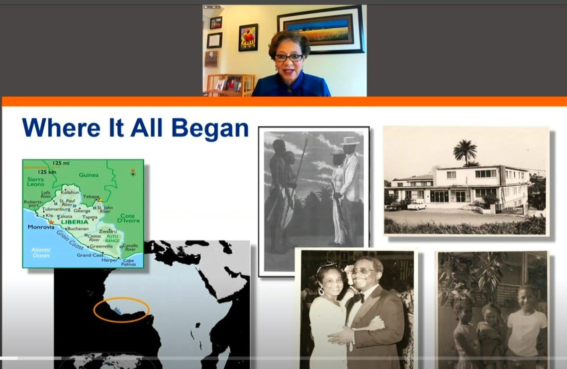 A slide shows photos of Dr. Cooper's parents, her with her siblings when they were children, a map of Liberia and the town where she grew up.