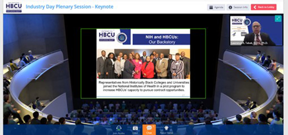 A large screen at the conference shows a group shot with the sign: NIH and HBCUs: Our back story