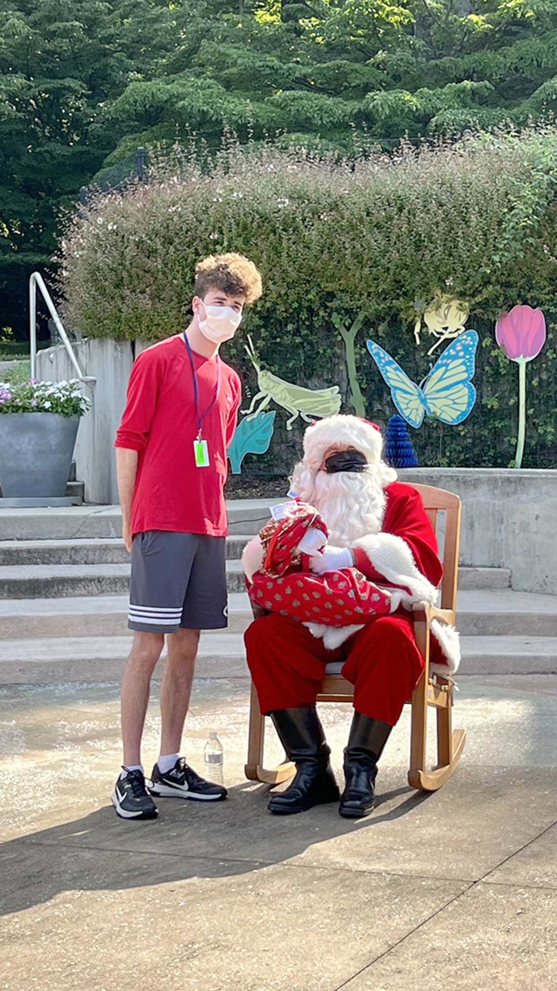 Youngster stands beside seated Santa