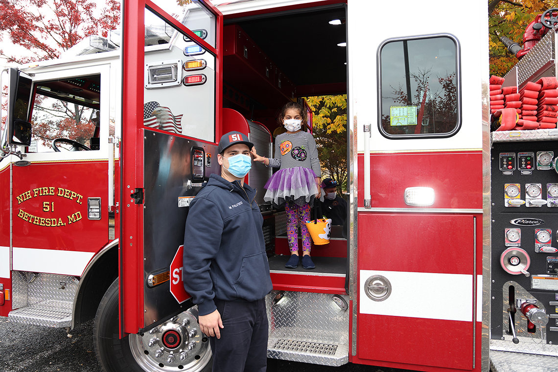 Firefighter with youngster aboard a fire engine