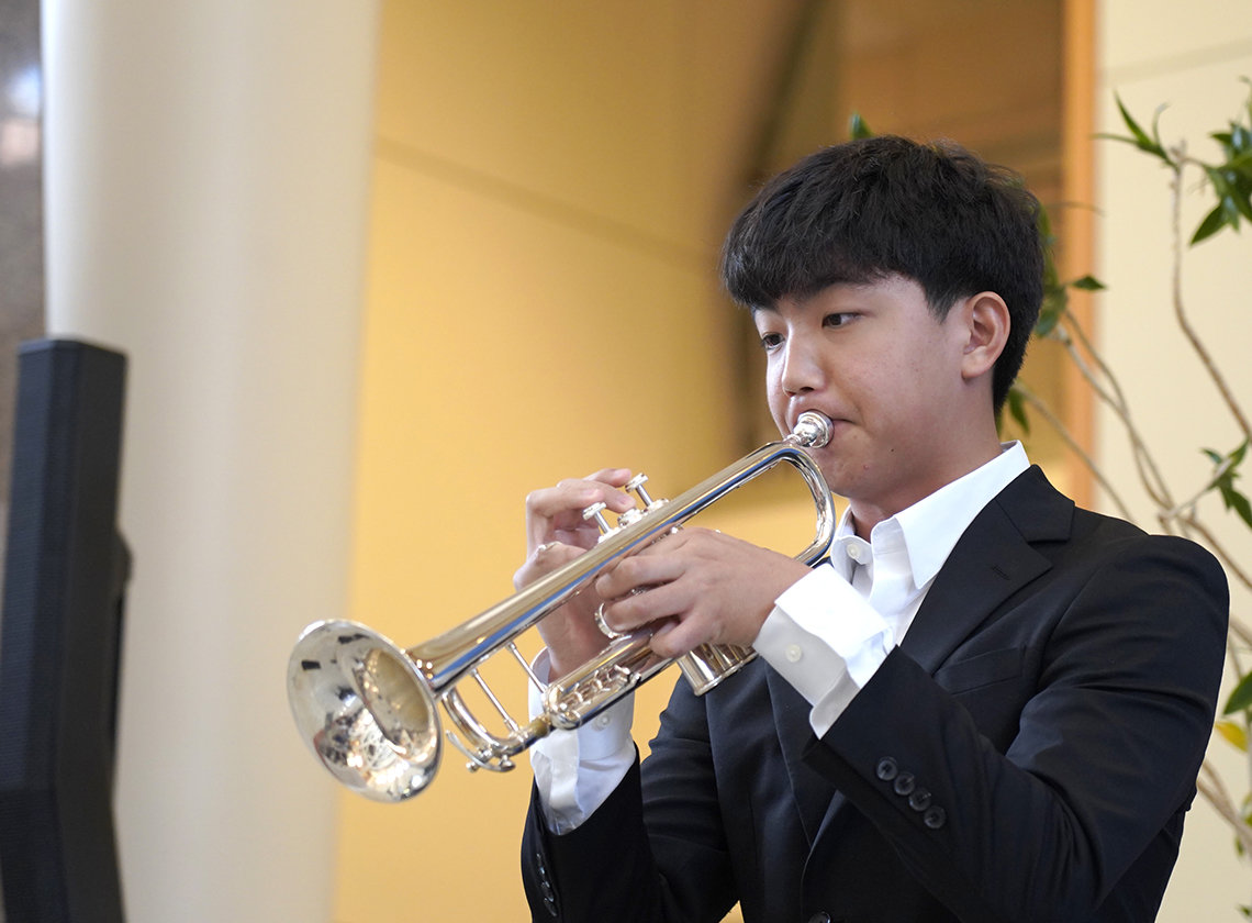 A young man plays trumpet in the CC atrium.