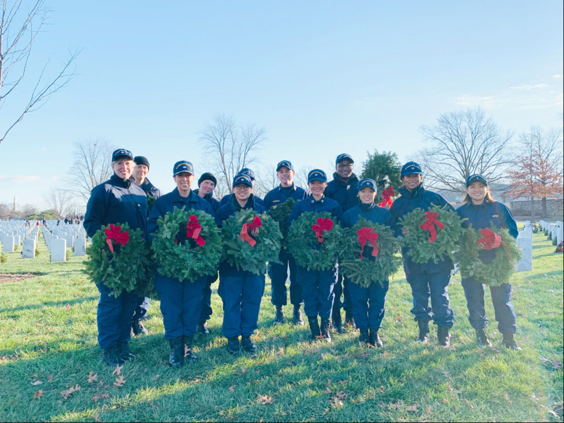 A group of officers hold wreaths at Arlington National Cemetery