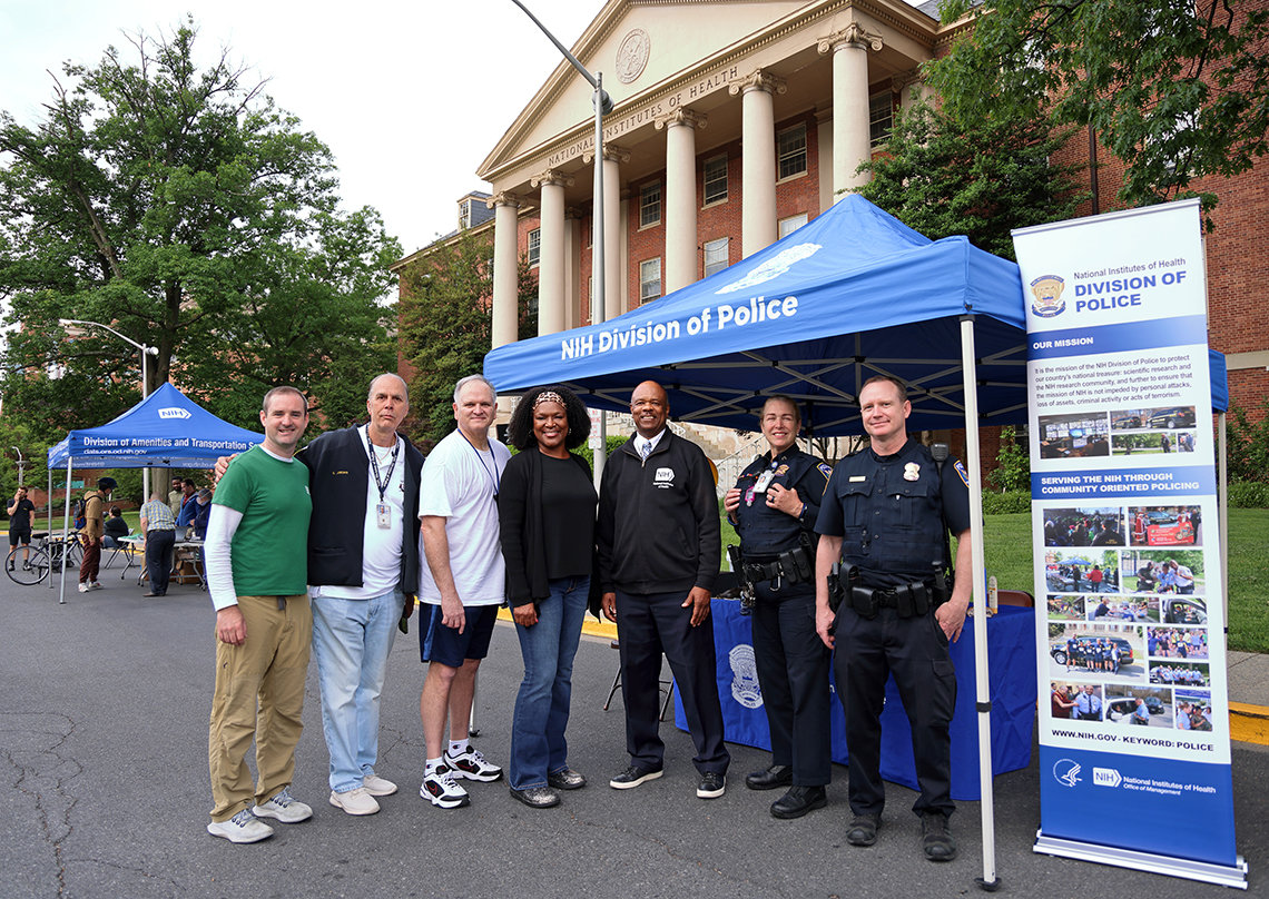 NIH Police officers and bike club members pose together under tent by Bldg. 1 pitstop