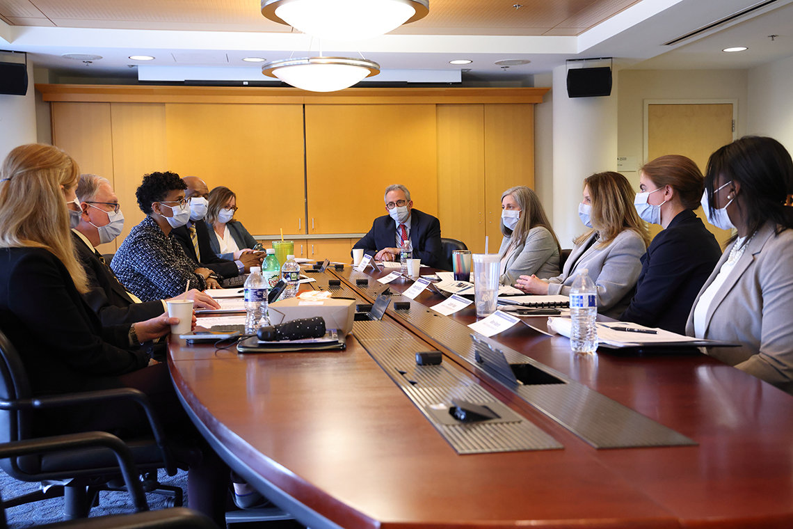 Palm talks with NIH leadership at a conference table