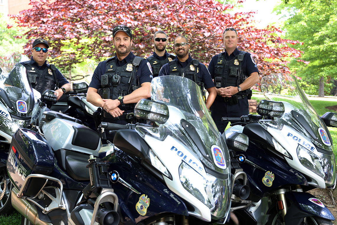 Several officers stand with their motorcycles.