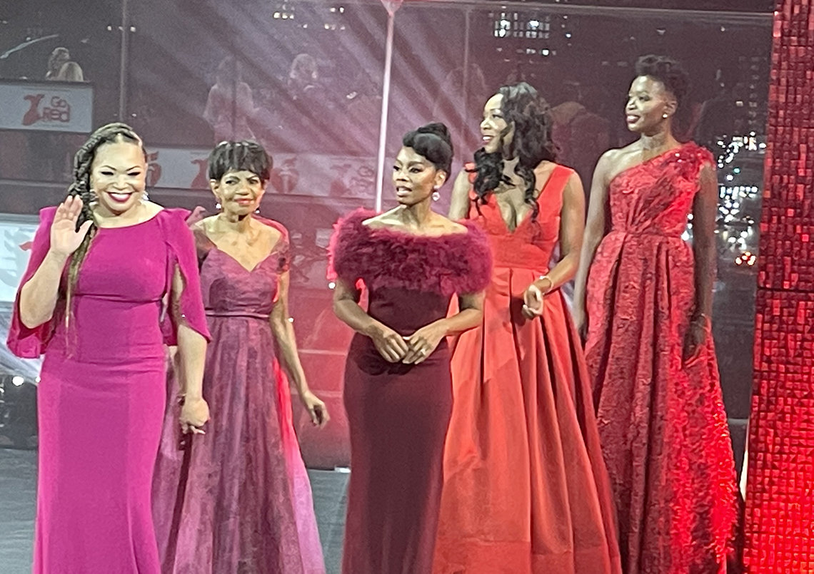 Women in red gowns on stage