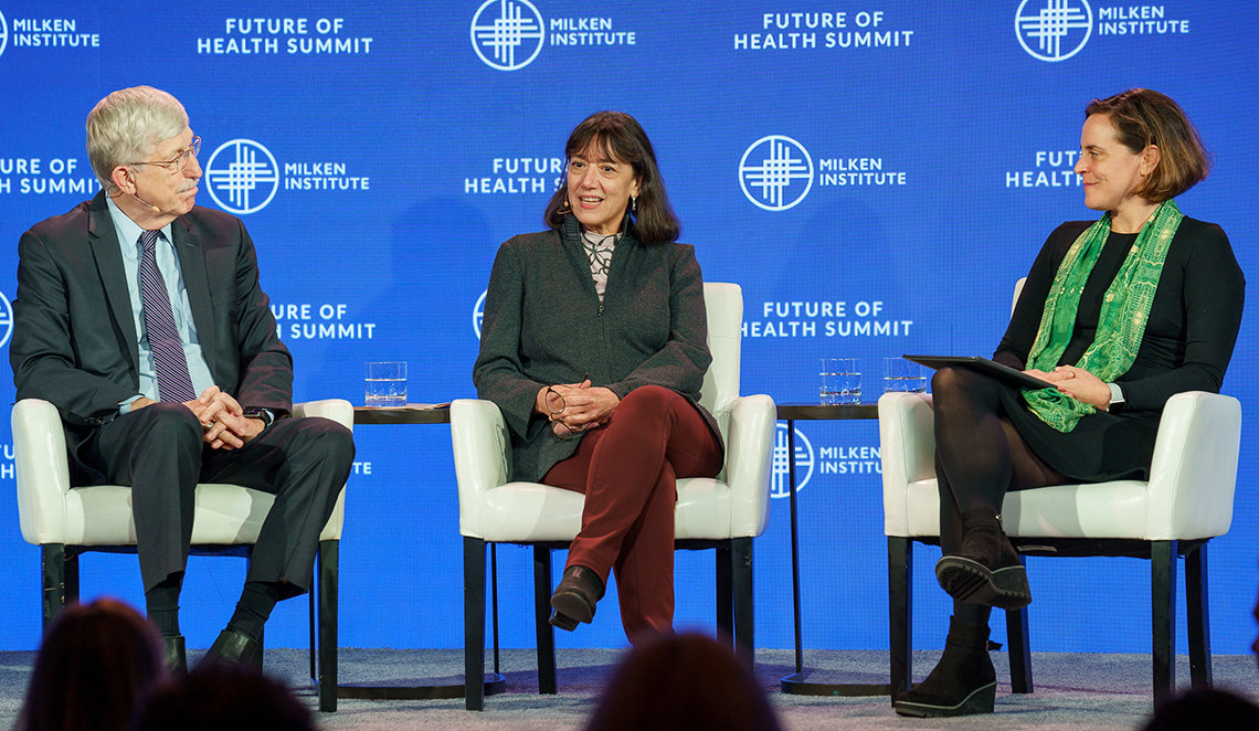Collins, Bertagnolli and Wegrzyn sit on stage with blue backdrop