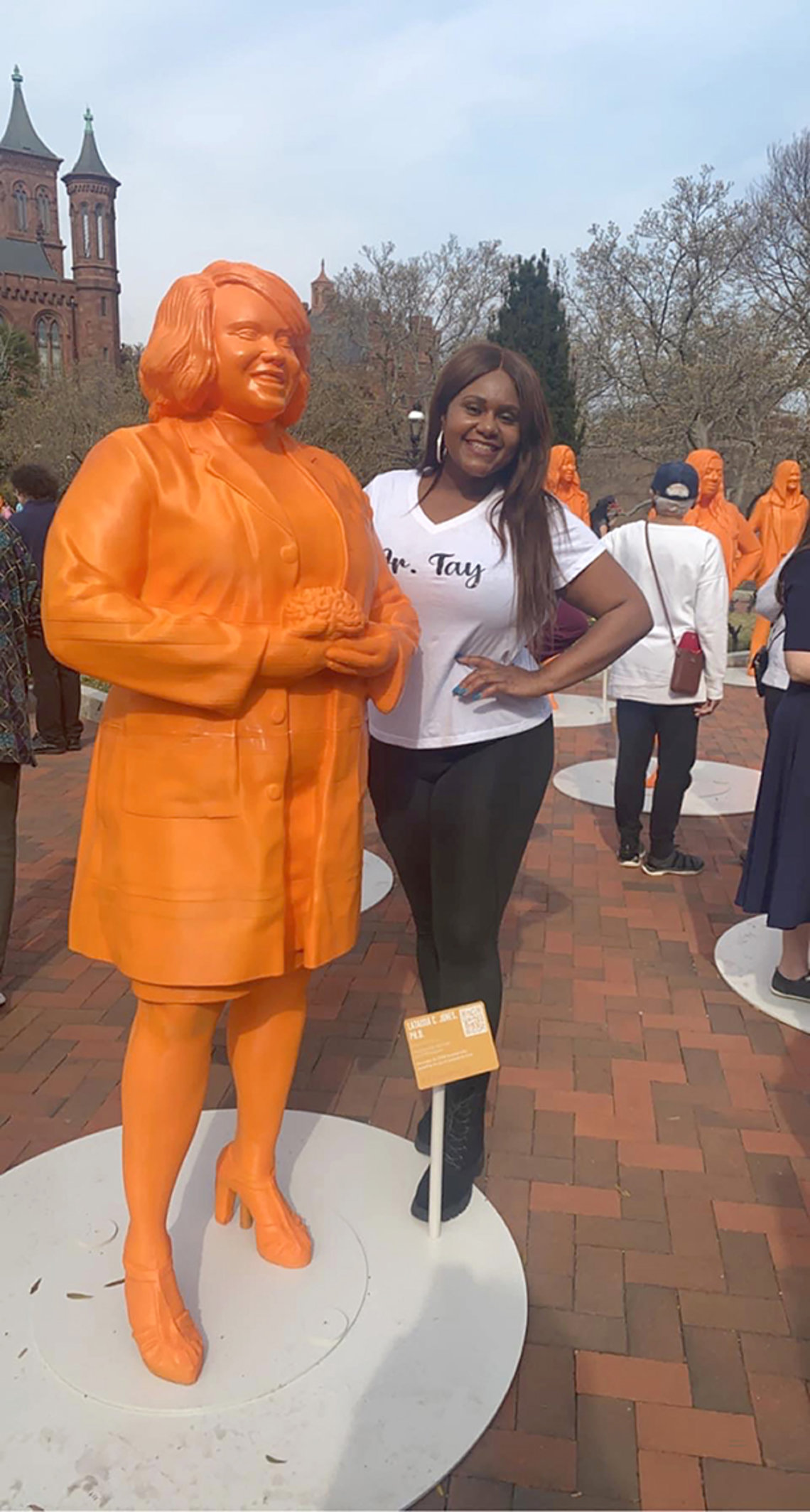 Jones stands next to an orange statue of her likeness