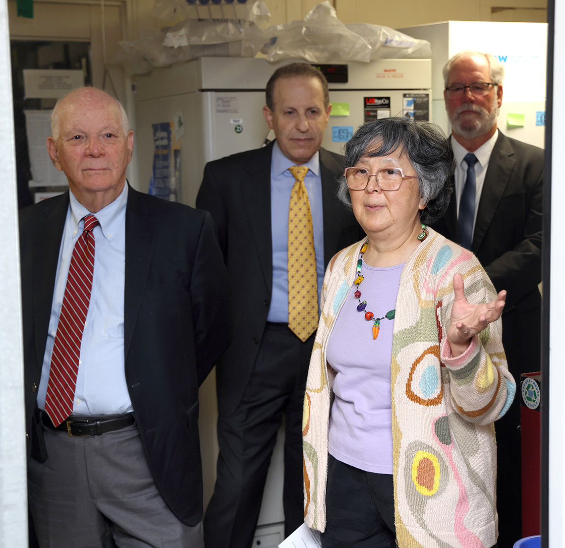 Cardin walks down a corridor with three NIH leaders.